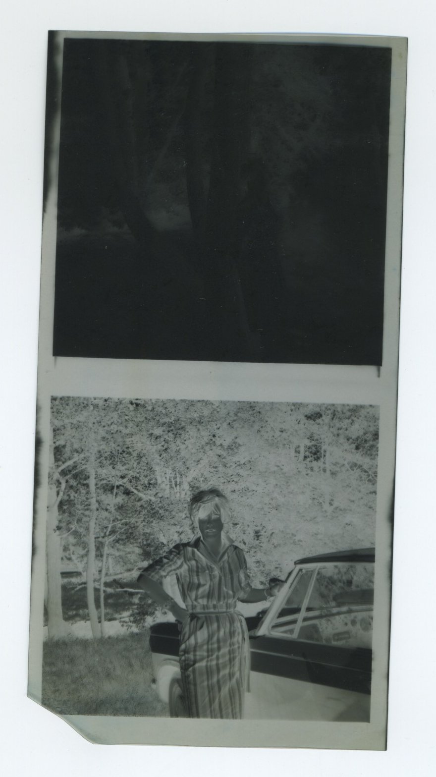 Young woman beside a car (original negative)
